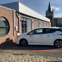 Elektrische wagen die oplaadt aan de bibliotheek