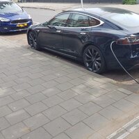 foto van voetpad met kabelgoottegels, ingeplugde wagen