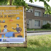 campagnebord met affiche opgeplakt tegen boom