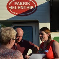 3 mensen die staan praten voor een mobiel energieloket