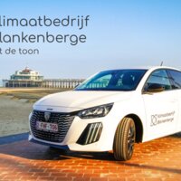 foto met op de voorgrond elektrisch voertuig met logo Klimaatbedrijf, achtergrond de zee en pier van Blankenberge